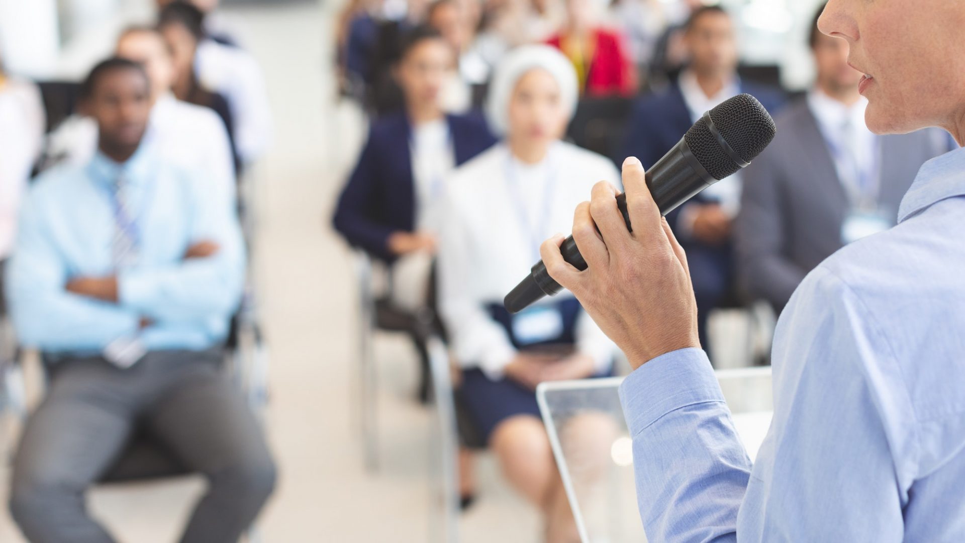 Female speaker speaks to diverse business people in business seminar in conference room